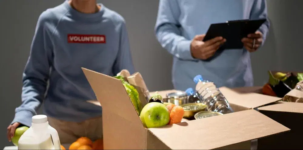 Volunteers packing a box of food